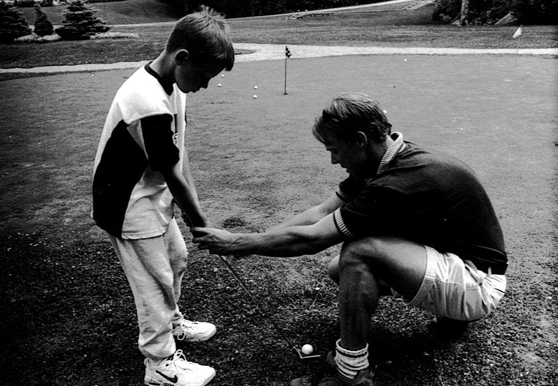 Camp Manitou counsellor teaching golf