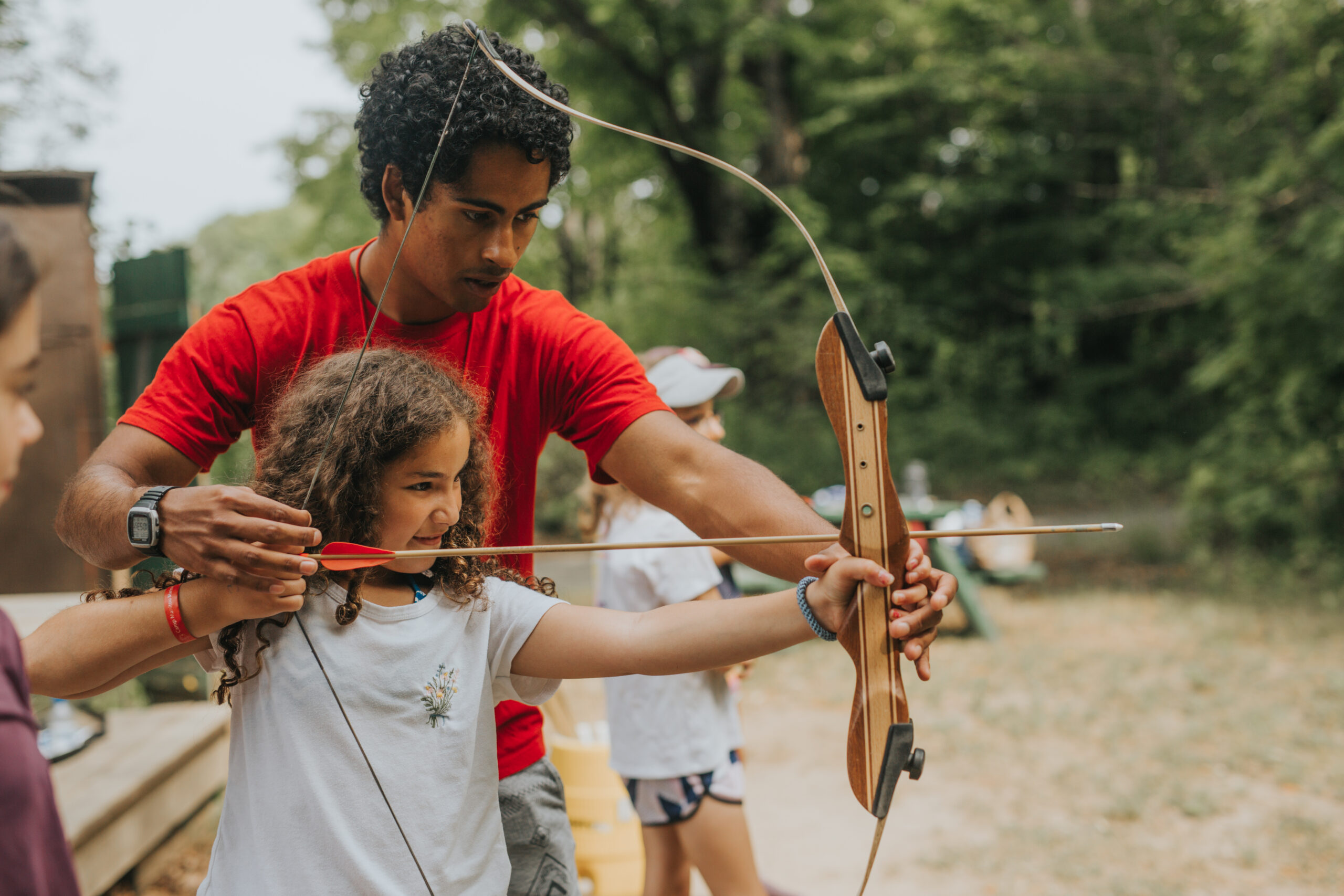 Camp Counselor teaching archery
